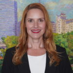 Portrait of Angela Cozby, Executive Director; Arts Council OKC in front of painting.