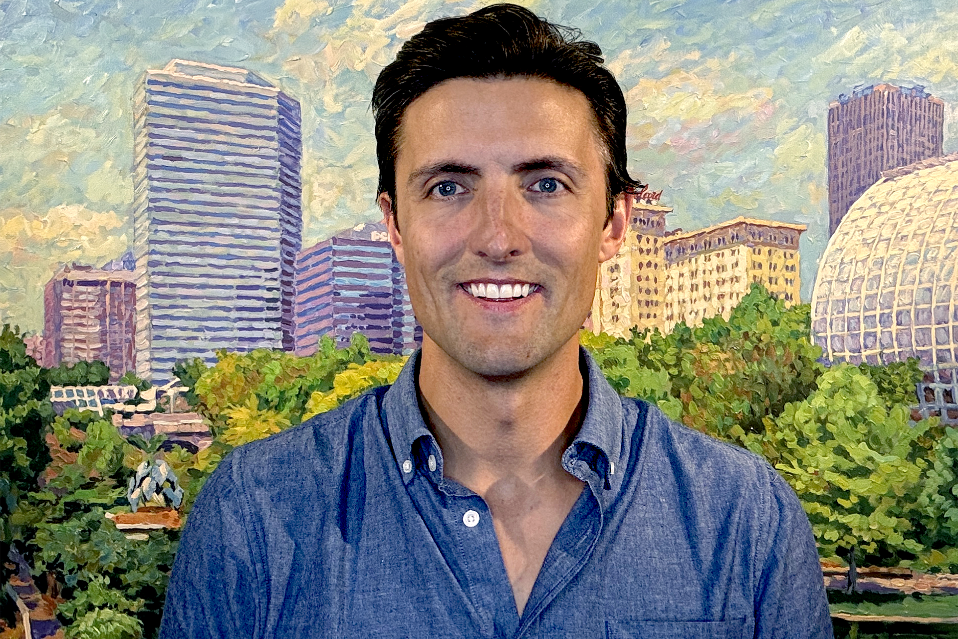 Director of Communications in front of Arts Council OKC Painting of Myriad Gardens.