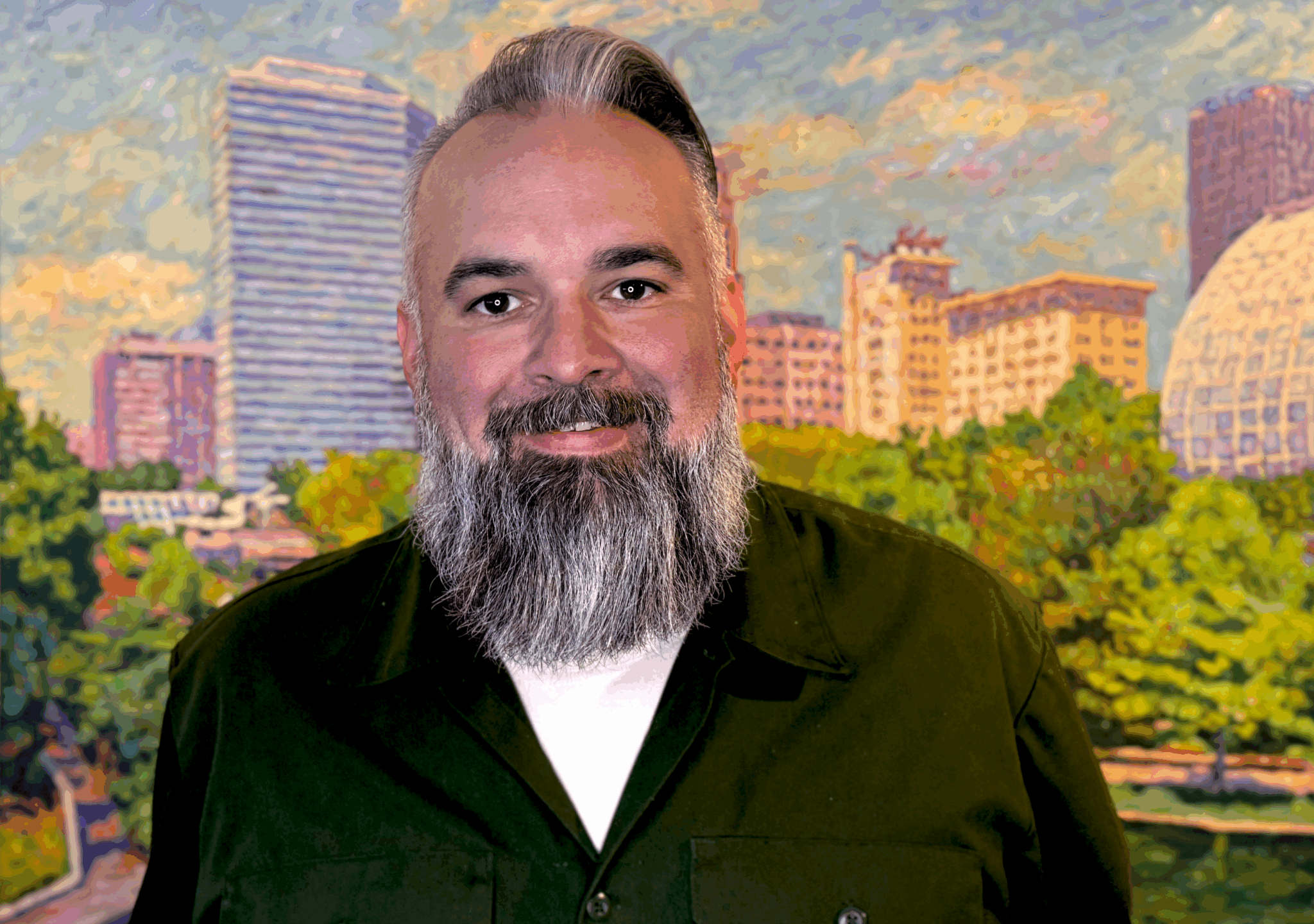 Bearded man in a black shirt smiling in front of a cityscape painting of Oklahoma City.