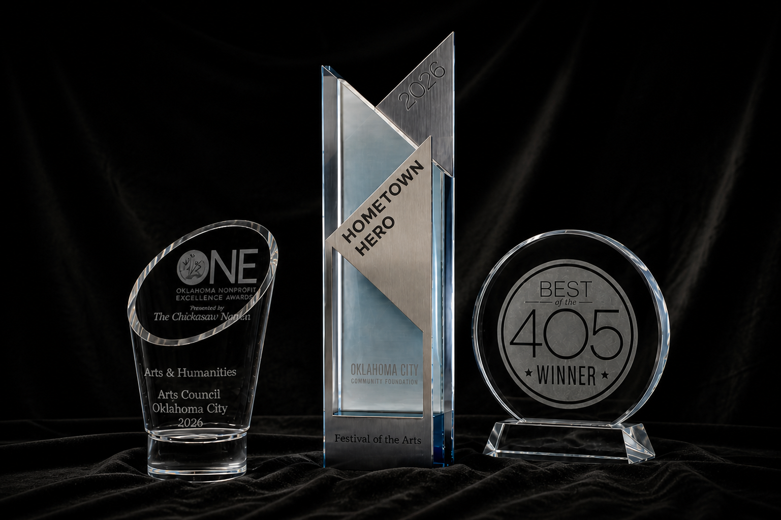 Three translucent awards on a black background: ONE non-profit excellence award, Hometown Heroes award, and Best of the 405 award.