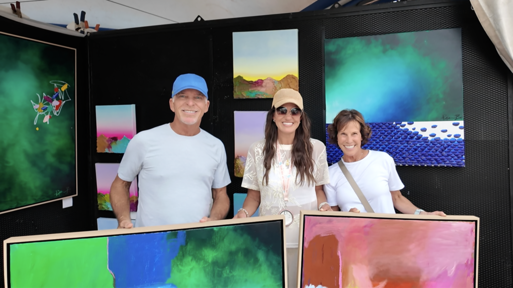 Painter Piper Bridwell standing with Festival of the Arts patrons after making a sale.